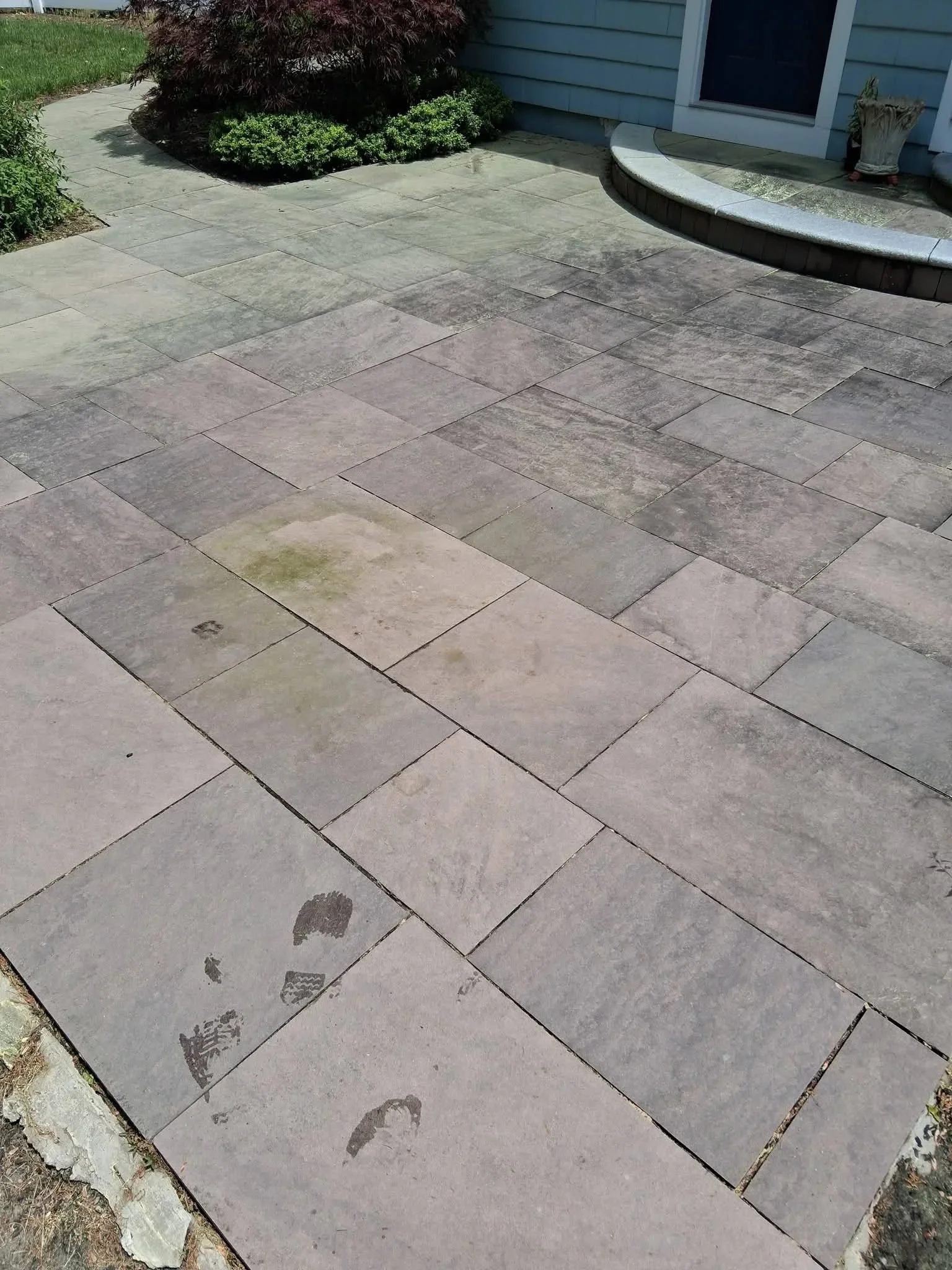 Flagstone patio with herringbone pattern after pressure washing, algae and stains removed