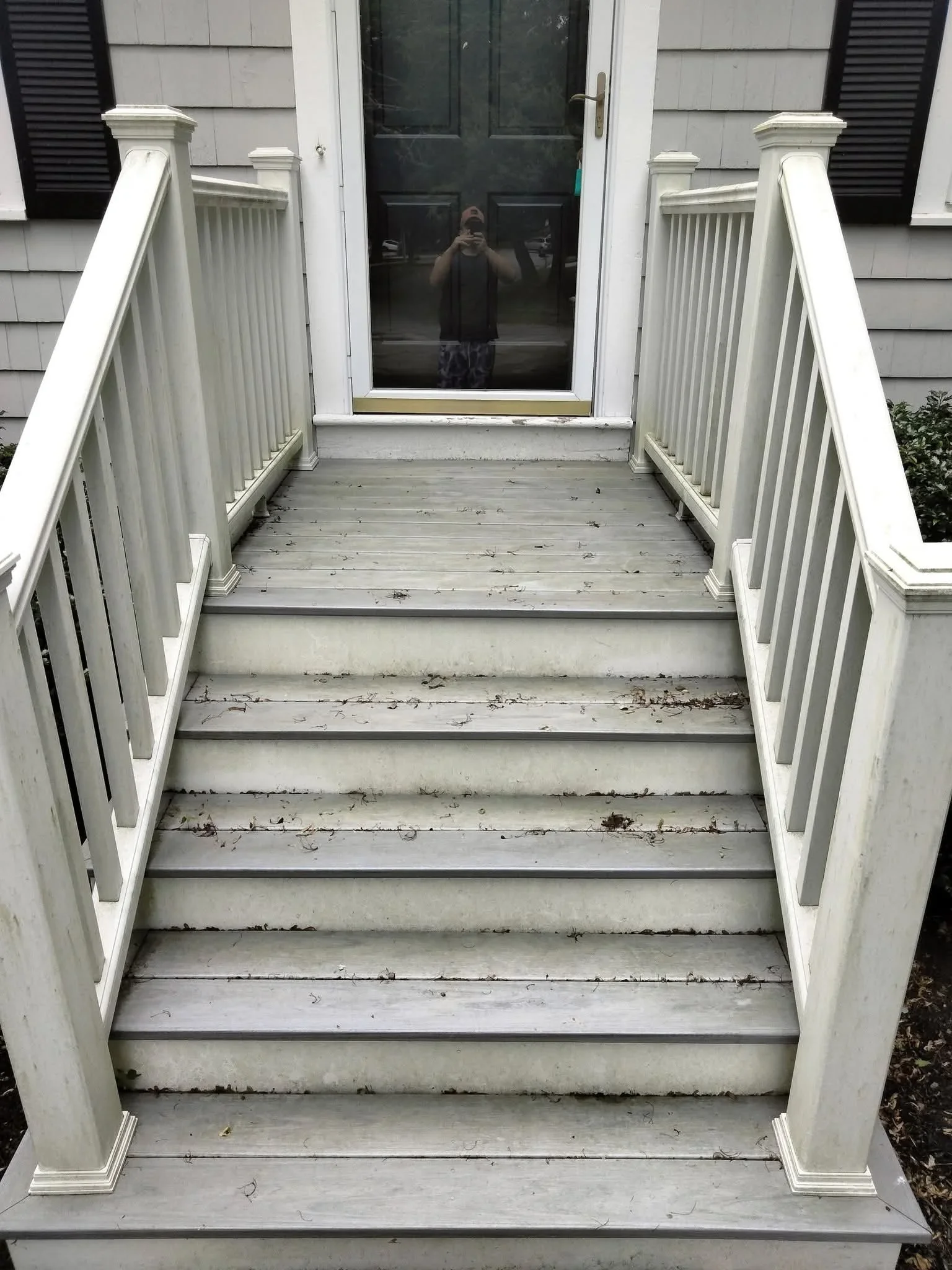 Concrete staircase with white railings and landing before pressure washing service